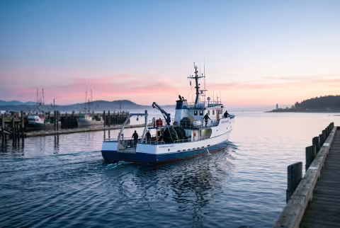 Research vessel departing the dock at dawn — Landing page imagery, aspirational hero.
